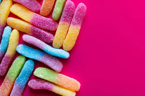 Flache Liege mit bunten Gelee-Bonbons auf rosa Oberfläche — Stockfoto