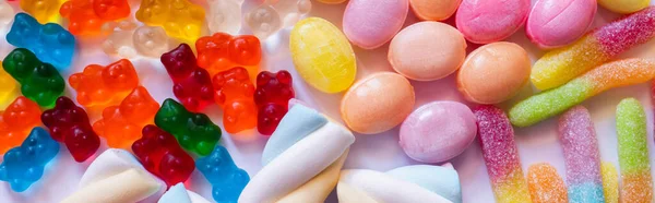 Top view of jelly bears near sweets on white background, banner — Stock Photo