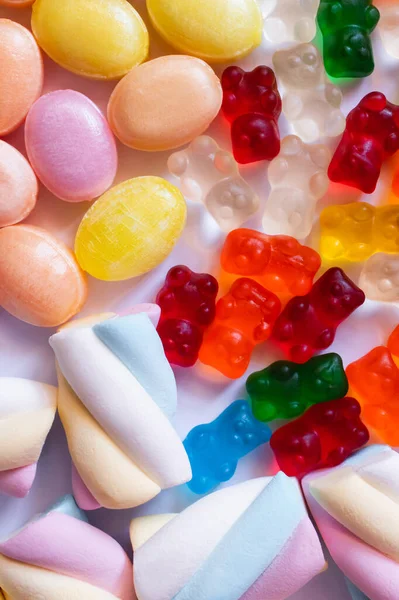 Nahaufnahme von Marshmallows und bunten Süßigkeiten auf weißem Hintergrund — Stockfoto