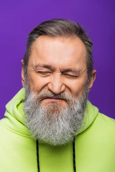 Retrato de hombre mayor con pelo gris y ojos cerrados aislados en púrpura - foto de stock