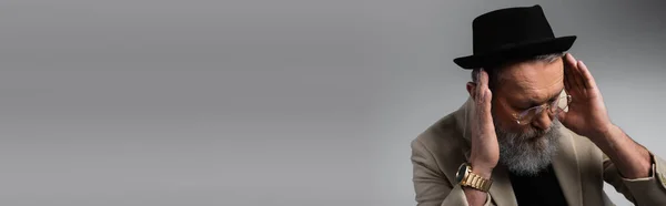 Bearded senior man in derby hat and eyeglasses looking down on grey, banner — Stock Photo