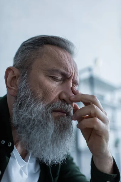 Portrait of sad senior man with wrinkles and closed eyes suffering crisis — Stock Photo