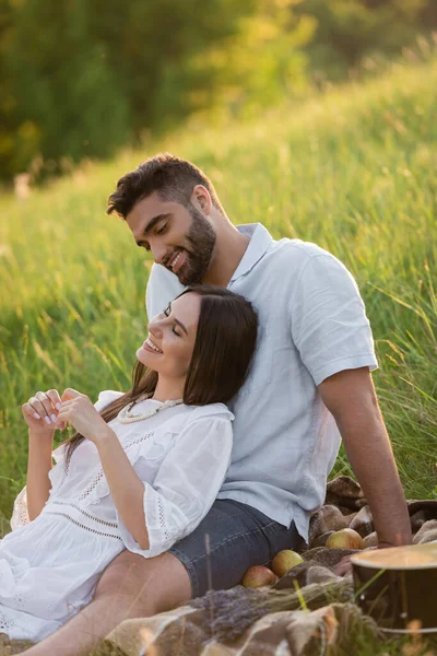 Homme barbu regardant femme heureuse souriant avec les yeux fermés sur la pelouse verte — Photo de stock