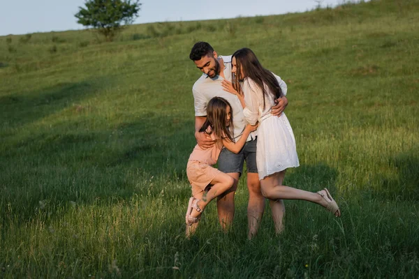 Volle Länge einer glücklichen Familie, die sich an einem Sommertag auf dem Feld umarmt — Stockfoto