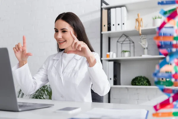 Smiling doctor gesturing during video call on laptop in hospital — Stockfoto