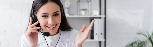 Fröhlicher Arzt im Kopfhörersprech in Klinik, Transparent — Stockfoto