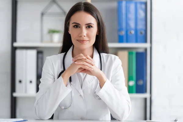 Brunette doctor looking at camera in clinic — Photo de stock