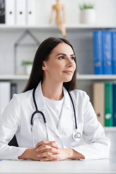 Portrait of brunette doctor looking away in clinic — Stock Photo