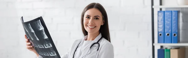 Positive doctor holding mri scan and looking at camera in clinic, banner — Stock Photo