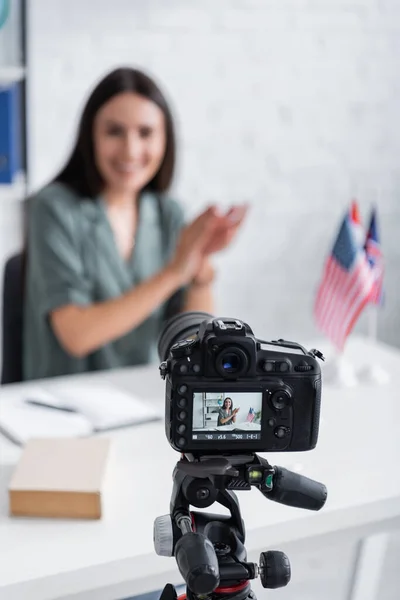 Digital camera near blurred teacher and flags in class — Stock Photo