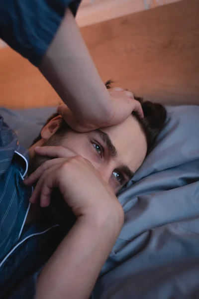 Man in pajama suffering from sleeplessness in bedroom — Stock Photo