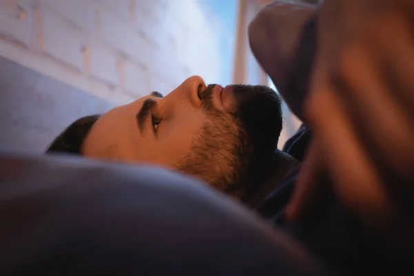 Worried man with sleep disorder lying on bed at night — Stock Photo