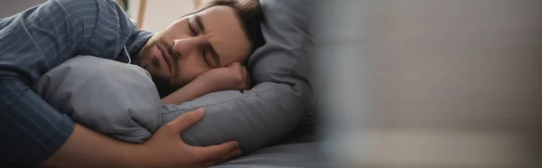 Homme en pyjama dormant sur le lit à la maison le matin, bannière — Photo de stock