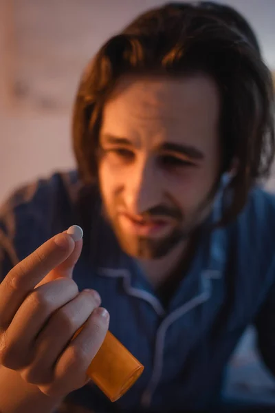 Pill in hand of blurred man with sleep disorder at home — Photo de stock