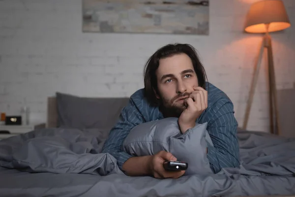 Homem com distúrbio do sono assistindo filme na cama à noite — Fotografia de Stock