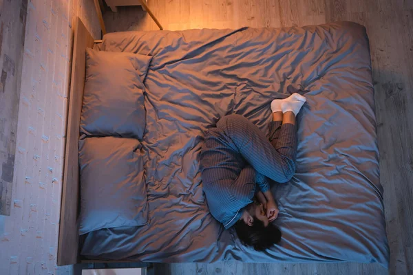 Seitenansicht eines jungen Mannes, der nachts auf dem Bett schläft — Stockfoto