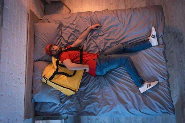 Blick von oben auf Schlafwandler in Kreißsaal-Uniform, der zu Hause im Bett schläft — Stockfoto