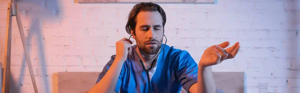 Young sleepwalker in doctor uniform and stethoscope at home, banner — Fotografia de Stock