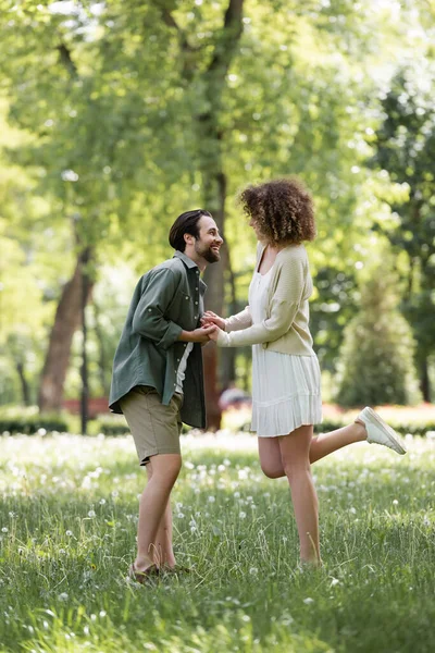 Full length of happy young couple having date in green park — Stockfoto