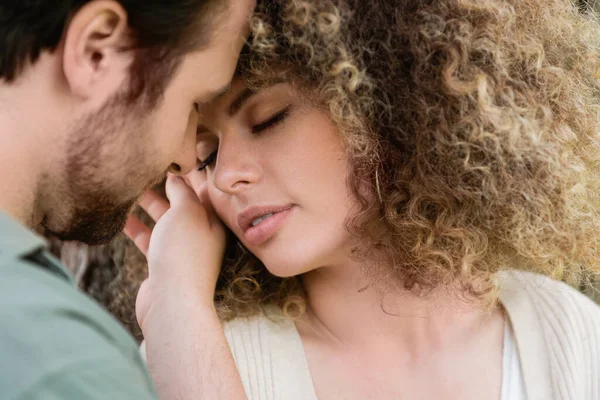 Portrait of young man touching face of curly and pretty woman — Stock Photo