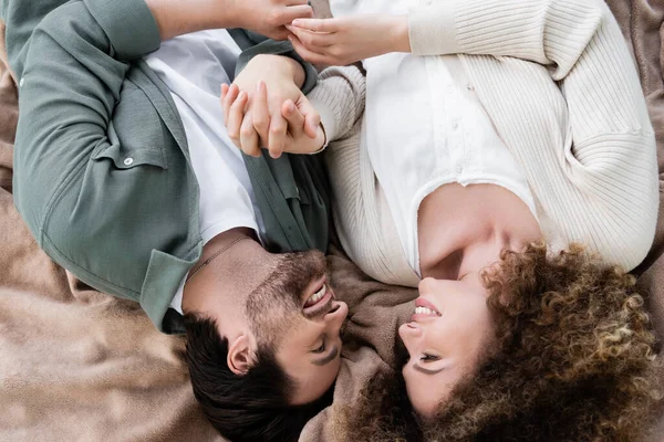 Top view of happy young woman and man lying on soft blanket — Stockfoto