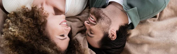 Top view of happy young woman and man lying on blanket, banner - foto de stock