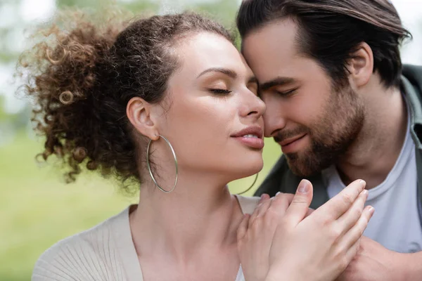 Retrato de mulher satisfeita com olhos fechados abraçando com homem barbudo — Fotografia de Stock