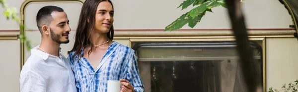 Gai gay homme tenant tasse de café tandis que debout avec copain près de Voyage van en été, bannière — Photo de stock