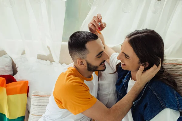 Alto ángulo vista de sonriente pareja gay mirando el uno al otro en van - foto de stock