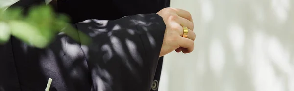 Обрезанный вид жениха в формальной одежде с золотым обручальным кольцом на пальце, баннер — стоковое фото