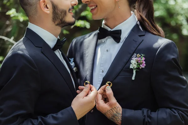 Cropped view of happy gay couple holding wedding rings in hands — Foto stock