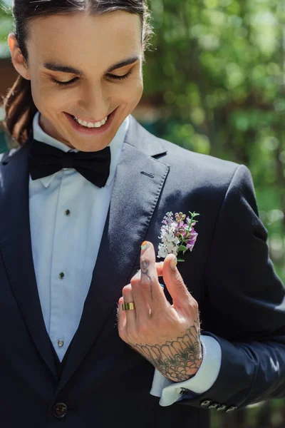 Happy tattooed man with golden wedding ring on finger smiling on wedding day — Stock Photo