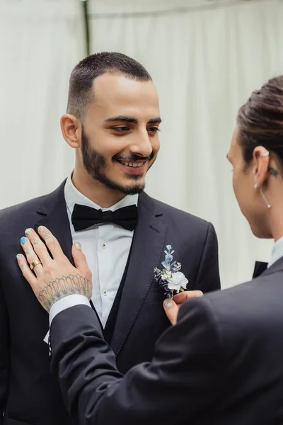 Tätowierte Homosexuell Mann Anpassung boutonniere auf Anzug der glücklich bärtigen Bräutigam — Stockfoto