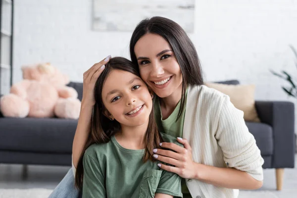 Portrait of smiling babysitter and happy girl looking at camera — Fotografia de Stock