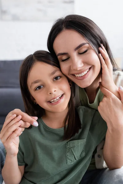 Porträt einer lächelnden Frau mit geschlossenen Augen und glücklichem Kind, das in die Kamera blickt — Stockfoto