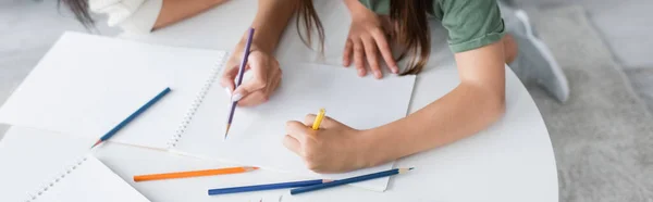 Vista ad alto angolo di babysitter e bambino disegno su carta, banner — Foto stock