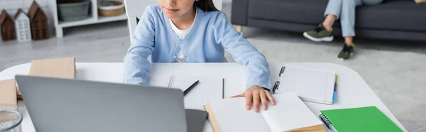 Partial view of girl doing homework near laptop and copybooks, banner — Foto stock