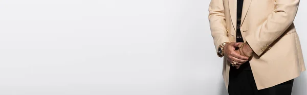 Vista ritagliata dell'artista hip hop con orologio da polso e anelli in piedi sul grigio, banner — Foto stock