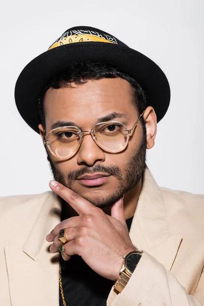 Portrait of eastern hip hop performer in fedora hat and eyeglasses isolated on grey — Photo de stock