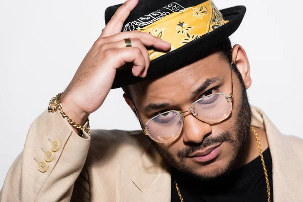 Портрет східної хіп-хоп співачки в окулярах, що регулюють капелюх фідори ізольовано на сірому — стокове фото