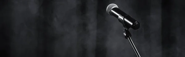 Microphone on stand on black stage with curtain and smoke, banner — Stock Photo