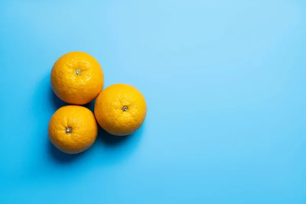 Draufsicht auf Orangen auf blauem Hintergrund mit Kopierraum — Stockfoto