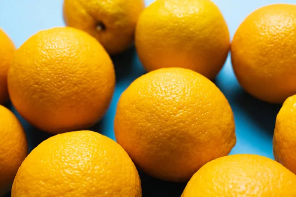 Vista de cerca de naranjas maduras sobre fondo azul - foto de stock