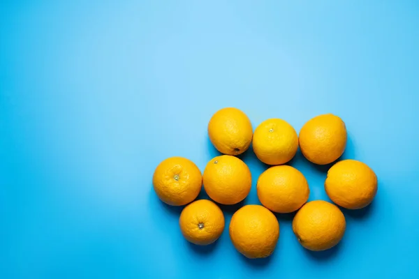 Vista superior de naranjas frescas sobre fondo azul - foto de stock