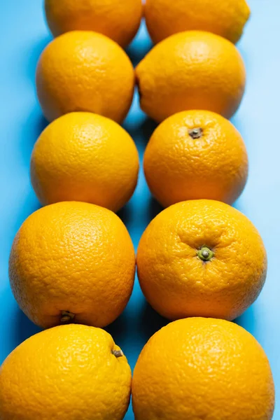 Vista de cerca de naranjas maduras sobre fondo azul - foto de stock