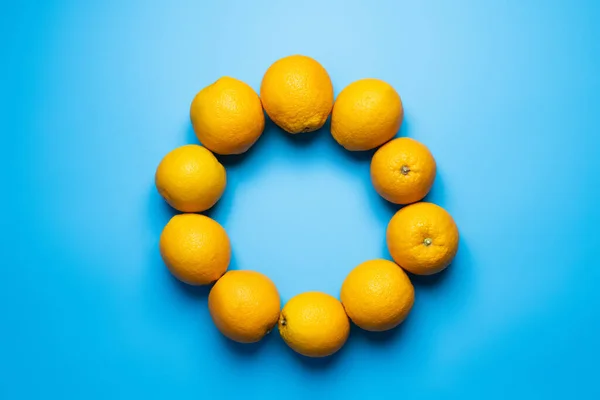 Colocação plana com moldura de laranjas no fundo azul — Fotografia de Stock