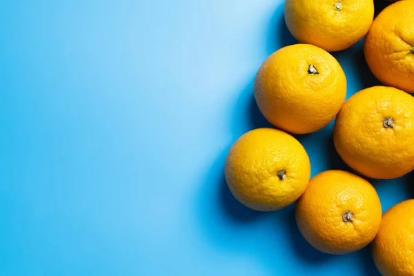 Top view of natural oranges on blue surface — Stock Photo