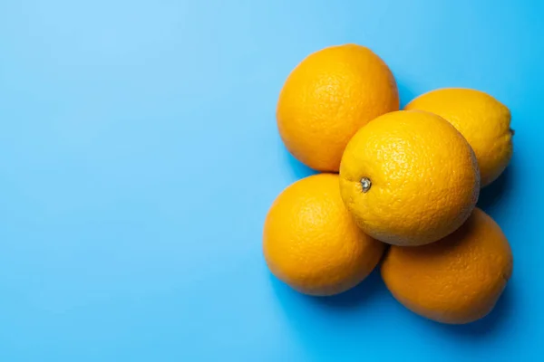Top view of bright oranges on blue background with copy space — Stock Photo