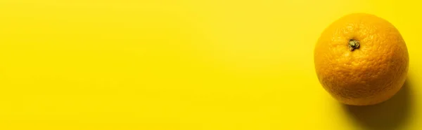 Top view of orange with shadow on yellow background, banner — Stockfoto