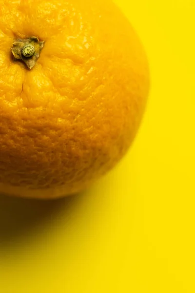 Close up view of orange in peel on yellow background — Foto stock